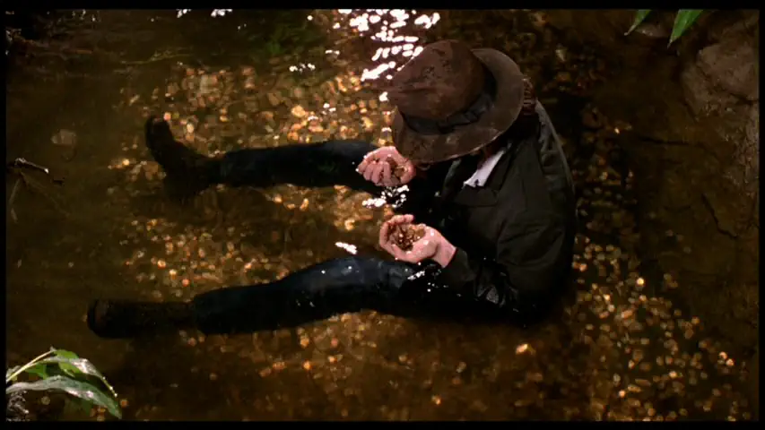 movie still of a zombie picking up change from a wishing well in the mall